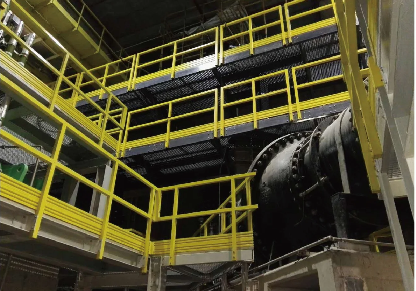 Yellow fiberglass handrail and guardrail systems around industrial platforms and stairs