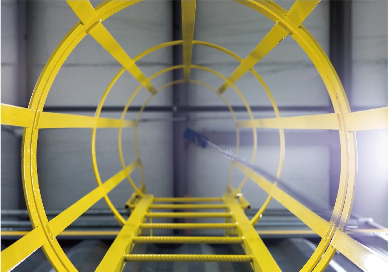 Yellow fiberglass fixed ladder with circular cage hoops and vertical cage strips
